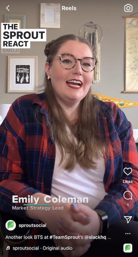 A Reel on Sprout Social's Instagram where an employee sits on a couch while wearing a plaid shirt over a white t shirt as she talks about her favorite Sprout react emoji in Slack.